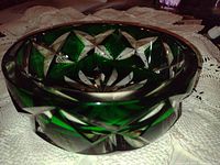 Side view of green lead crystal bowl showing geometric cut patterns and thickness of the glass.