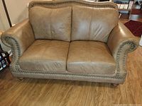 Front view of the tan leather love seat