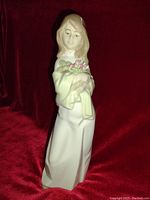 Front view of the Levantina porcelain lady figurine holding flowers, showing details of face, dress, and flowers.