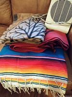 Three throws stacked on each other and Black & Decker electric heater showing all items in lot