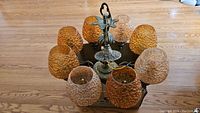 Chandelier placed on wooden floor showing all ten amber art glass shades and solid brass decorative frame and top fixture.
