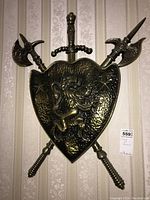 Front full view of coat of arms wall art mounted with sword and axes