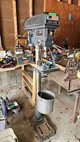 Full front view of floor-mounted drill press with stand and chip bucket