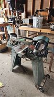 Front view of green Busy Bee bandsaw on pedestal stand in garage workshop