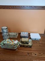 Serving dishes and bowl sets arranged on wood floor showing variety of patterns and metal stands