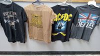 Full view of all four vintage band t-shirts displayed on hangers