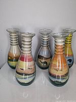 Front view of all 5 Arabian sand art vases showing their shape and colorful sand layers inside glass
