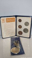 Display booklet open showing five British decimal coins minted in 1971 and informational text about the coins.