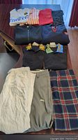 Photo showing all 6 clothing items: 3 pants and 3 shirts laid out on a table.