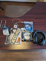 Overview of lot showing USB hub, remote control, cables, headphones and charger on table