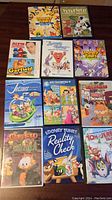 Overview of 10 DVD cases arranged on a table displaying classic animated children's movies such as Looney Tunes, Garfield, Alvin and the Chipmunks, and more.
