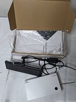 Nintendo DS original model handheld console, white color, charger with cable, and operation manual in box.