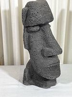 Front-left angled view of the Moai figure showing facial features and texture