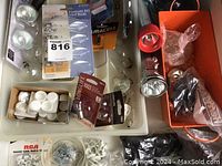 View of drawer with light bulbs, flashlight, and hardware items