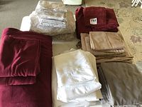 Multiple neatly folded bed sheets in various colors on table