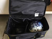 Open Elite rolling case showing blue and white Ebonite bowling ball inside