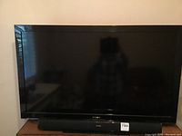 Sony Bravia TV with black screen sitting on top of a surface with Sakobs speaker bar underneath.