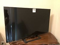 Front view of the black Sony flat screen TV on its stand.