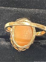 Front view of ring showing gold band and oval shell cameo from reverse side.