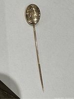 Full view of the stick pin showing the slender shaft and oval head