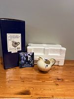 Photo of porcelain creamer/pitcher, original box, Styrofoam packaging with pamphlet showing dragonfly design and packaging details.