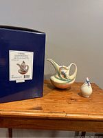 Franz Sahara Dragonfly Porcelain Coffee Pot with original box and small pamphlet on a wooden table.