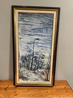 Full view of original oil painting Pine Ridge, vertically oriented with cloudy sky and winter landscape scene. Framed in original wooden frame.
