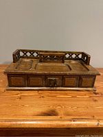 Front view of solid wood valet box with lattice railing and metal horseshoe latch