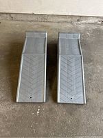 Top view of two silver Rhino car ramps with textured chevron pattern surfaces and raised edges.