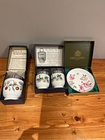 Photo showing one large egg coddler, set of 2 small egg coddlers, and Marissa trinket dish, all in original boxes on wooden surface.
