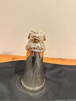 Front view of vintage silver plated stirrup cup with ram's head detail on top