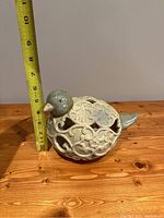 Photo showing front profile of the porcelain bird tea light holder with measuring tape indicating height about 3.5 inches.