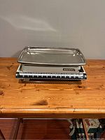 Side view of the vintage Soehnle mechanical food scale on wooden surface with tray visible and scale markings clear.