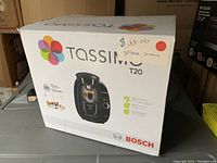Box front showing Bosch Tassimo T20 coffee maker in white damaged box with retail price $35 sticker and store demo red dot.