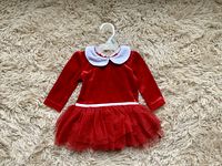 Red velvet 3-6 month baby Christmas dress with white collar and red tulle skirt laid flat on light carpet.