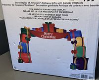 Image of box showing Airblown Archway Gifts inflatable arch with 'Merry Christmas' banner and colorful gift boxes.