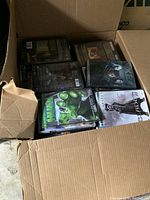 Photo of open cardboard box filled with DVDs showing various titles including Hulk and Resident Evil.