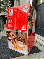 Photo of the damaged red box showing the lighted tinsel dog Christmas decoration holding a 'To Santa' sign, along with product information and brand label.