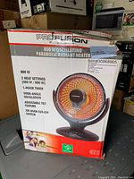 Damaged box of Profusion 800W oscillating parabolic radiant heater showing model and features.