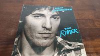Front cover of Bruce Springsteen 'The River' vinyl album showing a close up black and white photo of Bruce Springsteen's face.