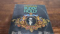Front cover of Buddy Holly vinyl record with portrait and decorative artwork.