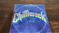 Front cover of Chilliwack Dreams Dreams Dreams vinyl album showing blue background and band name.
