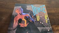 Front album cover of David Bowie's Lets Dance showing Bowie with boxing gloves.