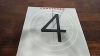 Front cover of Foreigner 4 vinyl album showing large black '4' and red 'Foreigner' text on gray background.