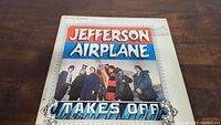 Front cover of Jefferson Airplane 'Takes Off' vinyl album showing band image and title.