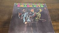 Front of the Smash Hits album cover showing Jimi Hendrix and band members in a stylized photograph with colorful title text.