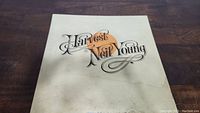 Front cover of Neil Young Harvest vinyl record featuring decorative title and orange heart graphic.