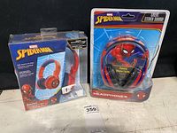 Two Spider-Man headphones, one in an open box, one in sealed plastic packaging with parental volume limiter.