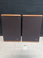 Front view of two Advent Baby 2 speakers with wood cases and black grilles, standing side by side.