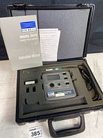 F.W. Bell Model 5070 Gauss Tesla Meter in black hard carrying case with foam and accessories, including instruction manual and cables.